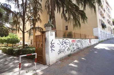 a wall with graffiti on it next to a building at Garbatella 2BR Holiday House in Rome
