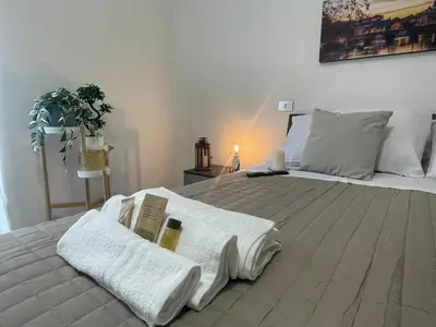 a bedroom with a large white bed with towels on it at San Lorenzo Private Apartment in Rome