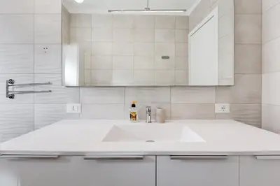 a white bathroom with a sink and a mirror at HYRIA Holiday Home in Rome