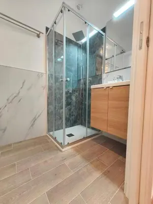 a bathroom with a shower with a glass door at MC Apartment Trastevere in Rome
