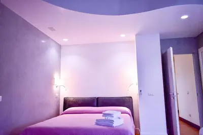a bedroom with a bed with pink sheets and a mirror at Domus DiDio in Rome
