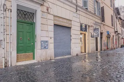an empty street with green doors on a building at Exclusive Campo dei Fiori Flat in Rome