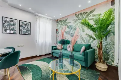 a living room with a green couch and a table at Koma 7 Apartment in Rome