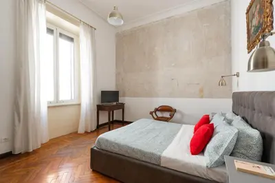 a bedroom with a bed with red pillows on it at La Stella Apartment by Hostand in Rome