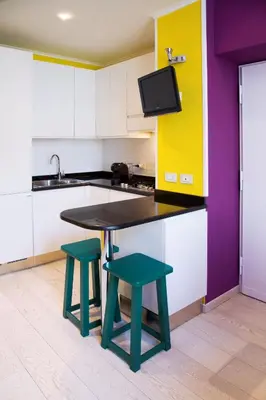 a kitchen with a table and two stools at Violet House in Rome