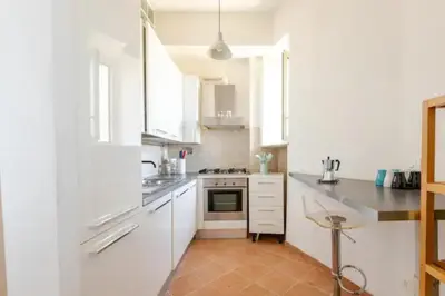 a kitchen with white cabinets and a stove top oven at Porta Maggiore Cozy Apartment in Rome