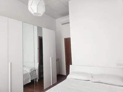 a bedroom with a white bed and a mirror at Aris Square Rome in Rome