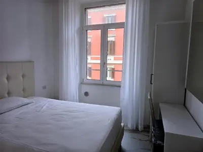 a white bedroom with a bed and a window at Aris Square Rome in Rome