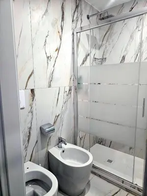 a white bathroom with a toilet and a sink at Aris Square Rome in Rome