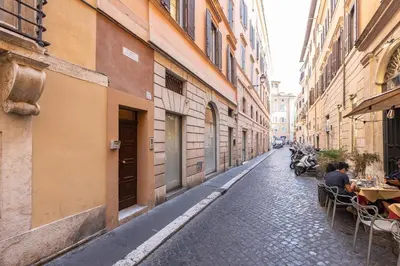 an alley with people sitting at tables on a street at Amazing Domus Ruspoli in Rome
