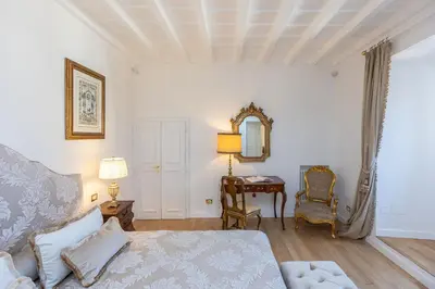 a bedroom with a bed and a table and a mirror at Amazing Domus Ruspoli in Rome