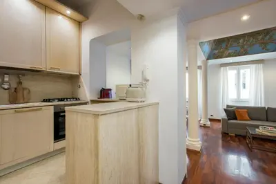 a kitchen with a counter and a living room at Boschetto Boutique Apartment in Rome