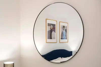 a mirror hanging on a wall with two framed pictures at Boschetto Boutique Apartment in Rome