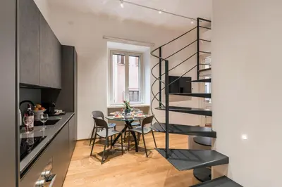 a kitchen and dining room with a spiral staircase in a apartment at The Best Rent - One-bedroom flat in Tritone area in Rome