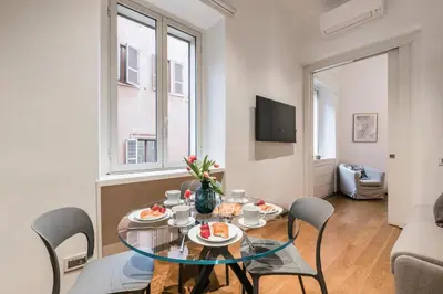 a dining room with a glass table and chairs at The Best Rent - One-bedroom flat in Tritone area in Rome