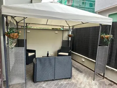 a table and chairs under a white umbrella on a patio at My Suite in Vatican - big terrace in Rome