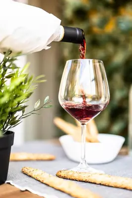 a person pouring wine into a wine glass at Dave's Home In Trastevere in Rome