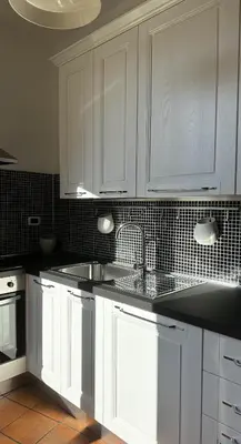 a kitchen with white cabinets and a sink at ColleVaticano Roma in Rome