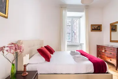 a bedroom with a bed with red pillows and a dresser at iFlat A Peaceful Nest In The Eternal City in Rome