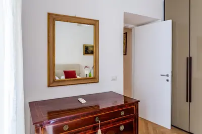 a mirror above a wooden dresser in a room at iFlat A Peaceful Nest In The Eternal City in Rome