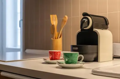 two cups on a counter next to a coffee maker at iFlat A Peaceful Nest In The Eternal City in Rome