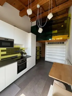 a kitchen with white cabinets and a black stove at Casa indipendente con vista acquedotto romano in Rome