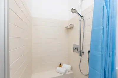 a bathroom with a shower with a blue shower curtain at Amazing Ponte Milvio in Rome