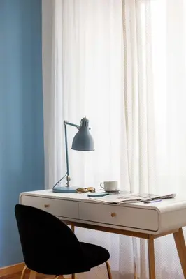 a desk with a lamp and a chair next to a window at Trieste Guesthouse - ZENO 48 in Rome