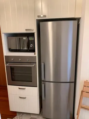 a stainless steel refrigerator in a kitchen with a microwave at Harmony Apartment Via Veneto in Rome