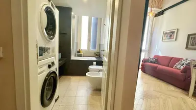 a bathroom with a washing machine and a red couch at Rome Like Home in Rome