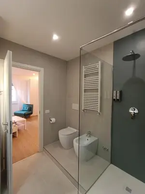 a bathroom with a toilet and a glass shower at King's Place in Rome