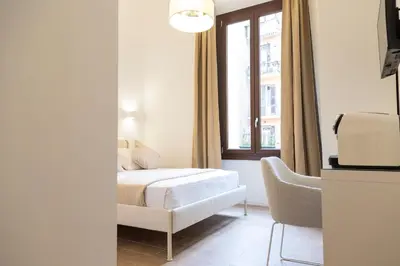a bedroom with a bed and a chair and a window at Relais Borsieri in Rome