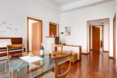 a living room with a glass table and a piano at Casa a San Giovanni - Charming Flat in Rome in Rome