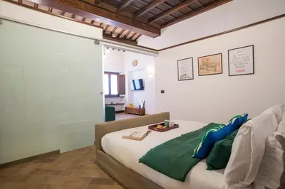 a bedroom with a bed with green and blue pillows at Cacio e Pepe FLATS 1 & 2 in Rome