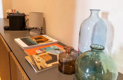 a table with two glass bottles and books on it at Cunabu Urbano V in Rome