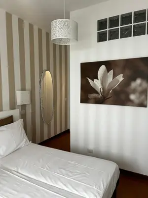 a bedroom with a white bed and a mirror at Appartamento San Pietro Alla Cupola in Rome
