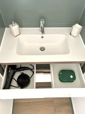 a white sink in a white counter with a green bag under it at Green House Rome in Rome