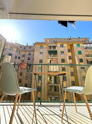 two chairs and a table on a balcony with a building at Green House Rome in Rome