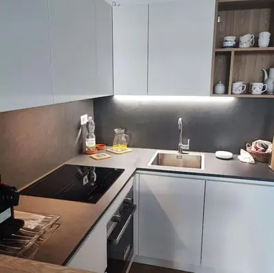 a kitchen with white cabinets and a sink at Monolocale nuova costruzione con giardino in Rome