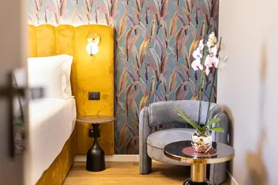 a bedroom with a bed and a chair and a table at Mavi Luxury Suites in Rome