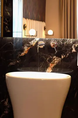 a bathroom with a sink and a black counter at Mavi Luxury Suites in Rome