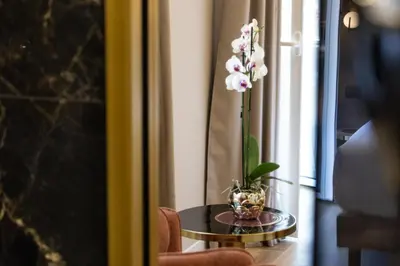 a table with a vase with flowers on it at Mavi Luxury Suites in Rome