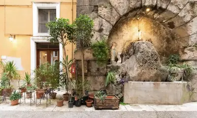 a courtyard with a fountain with potted plants at Roma magica in Rome