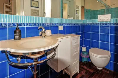 a blue tiled bathroom with a sink and a toilet at E&L apt 150sqm 3BR Metro 30m Park in Rome