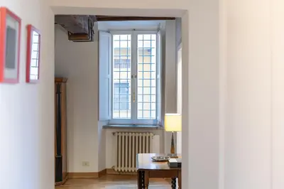 a hallway with a window and a table with a lamp at Santa Margherita by Rental in Rome in Rome