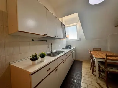 a kitchen with a sink and a table with a dining room at Lux Apartment Tuscolano in Rome