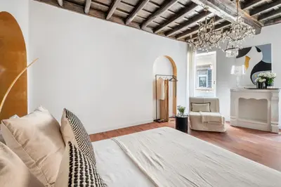 a living room with a bed and a chandelier at JSuite in Rome