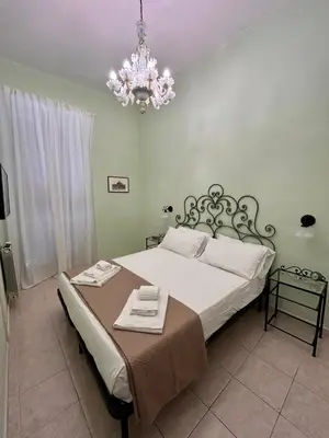 a bedroom with a large bed with a chandelier at DOMUS Laura VATICANO in Rome