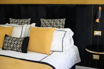 a bed with yellow and white pillows on it at Mazzini City Center Apartment - Vaticano - Foro Italico - Stadio Olimpico-Rai Delle Vittorie in Rome