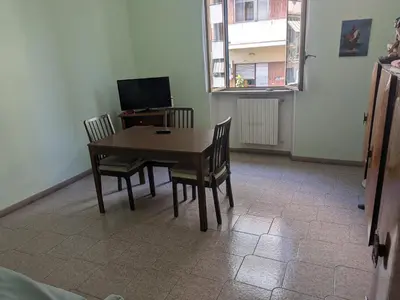 a dining room with a table and chairs and a television at Torpigna house in Rome